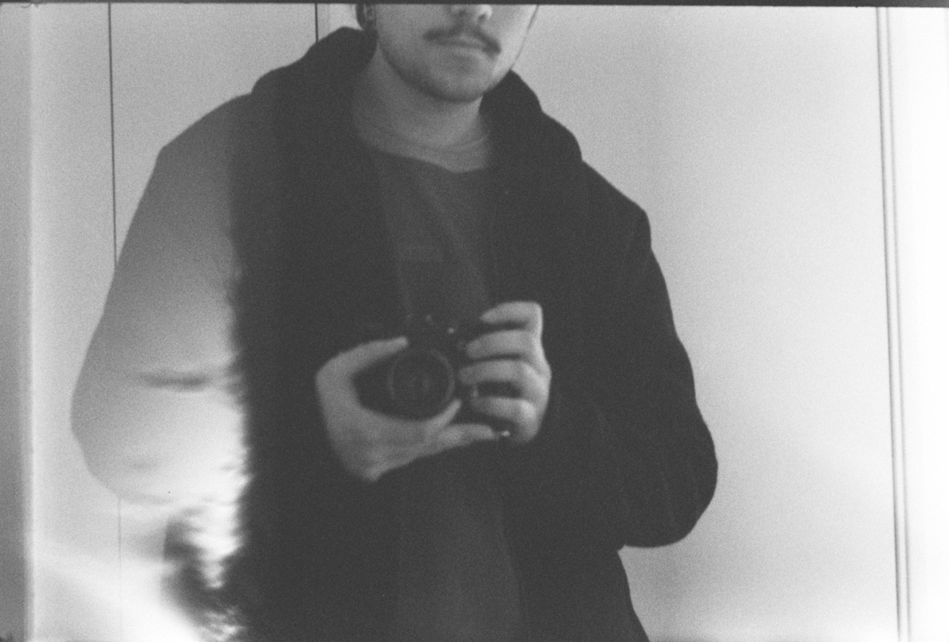 Autoretrato en blanco y negro tomado con una camara analoga en un espejo